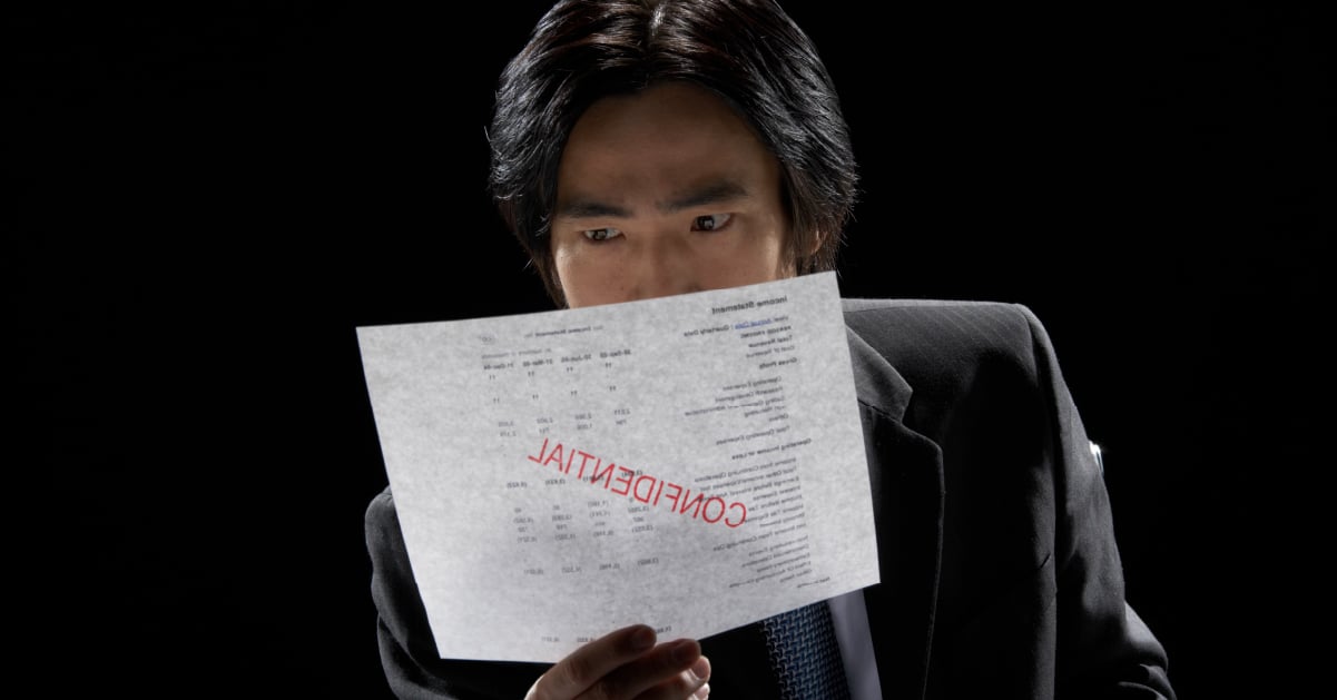 Male employee finds confidential information left lying in the print tray, highlighting the need for pull printing (follow-me printing) software.