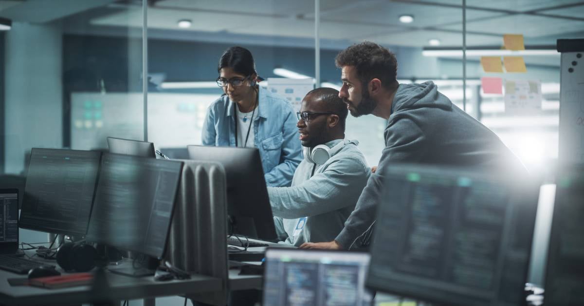 A cybersecurity team views a secruity alert after hours.