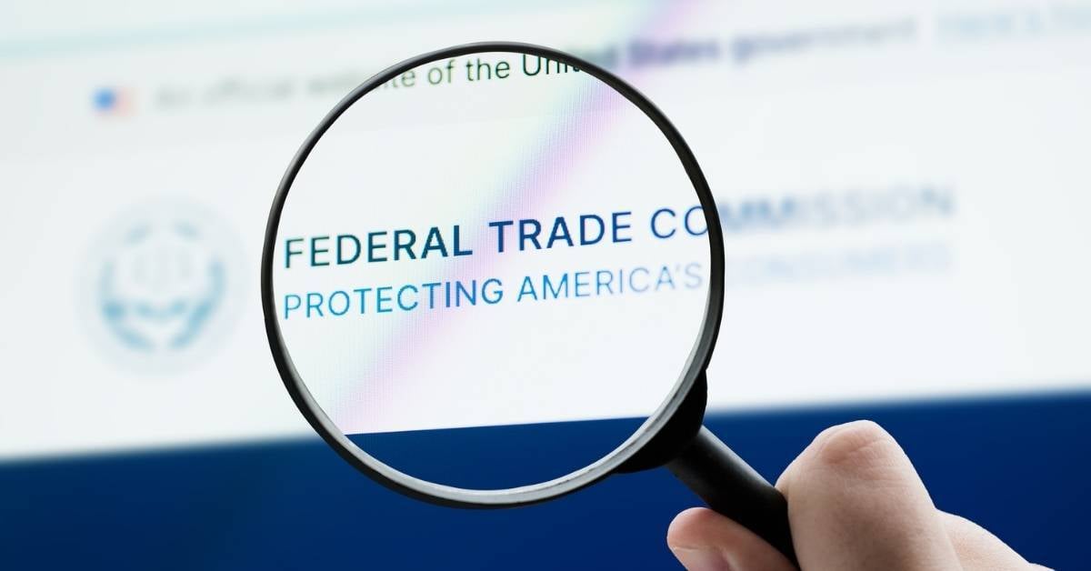 A magnifying glass hovers over the FCC Trade Commission website