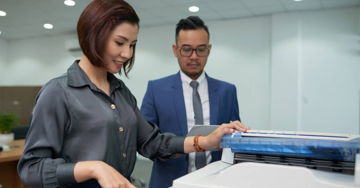 A print expert demonstrates device features for a female buyer