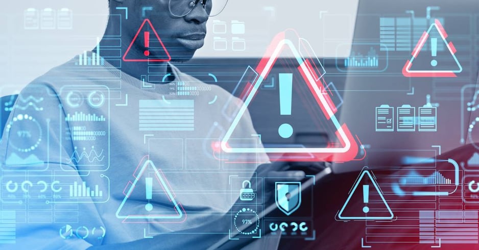 Digitized depictions of security alerts superimposed over a cybersecurity professional at work.