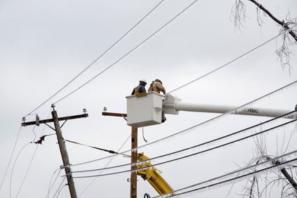 Electrical workers up in a bucket working on power lines