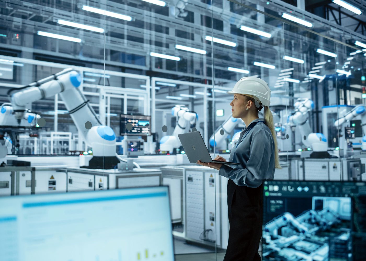 Person using laptop with iot tech in factory