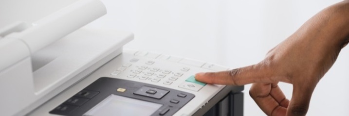 someone pressing print on a multi-function printer