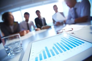 Image of people in a board room reviewing statistics